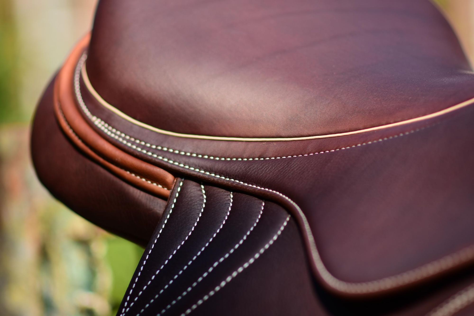 Burgundy saddle with contrast stitching, close-up